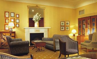 a living room with a fireplace , two couches , and chairs arranged around the room , creating a cozy atmosphere at Mercure York Fairfield Manor Hotel