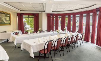 a long dining table set up for a formal event , with several chairs arranged around it at Barkly Motorlodge