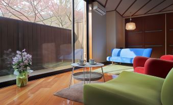 a modern living room with wooden floors , blue and green sofas , and a small table at Moritaya