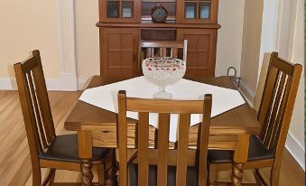 a dining room with a wooden table and chairs , along with a dining table in the background at Dolan House B&B