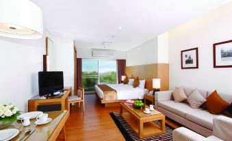 a hotel room with a king - sized bed , a flat - screen tv , a couch , and a dining table at Kantary Hotel Kabinburi