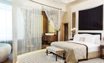 a large bed with a white comforter is in the center of a room with a patterned floor at DoubleTree by Hilton Gaziantep