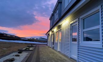 a beautiful sunset over a building , with the sun setting behind it and clouds in the sky at Motel Arctic Wind