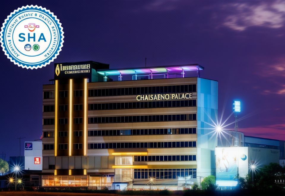 "a large hotel building with the name "" chaisenno palace "" prominently displayed on its front , illuminated at night" at Chaisaeng Palace Hotel