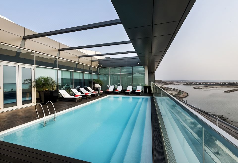 a rooftop pool with lounge chairs and a view of the ocean , providing a relaxing atmosphere at Hotel Baia