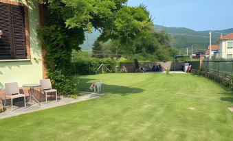 a backyard with a large green lawn , a hot tub , and a trampoline surrounded by trees at La Fornace