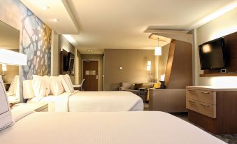 a modern hotel room with two beds , white bedding , and a couch , as well as other furniture at Courtyard Philadelphia Bensalem