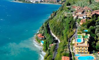 aerial view of a residential area by the sea , featuring houses , swimming pools , and lush greenery at All Inclusive Hotel Piccolo Paradiso