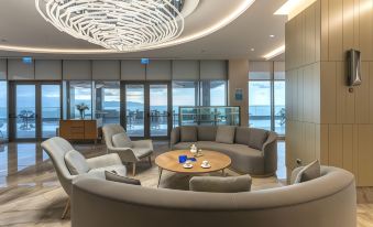 a modern living room with a large circular table and several chairs arranged around it at Radisson Blu Hotel Trabzon