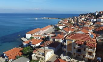 a picturesque view of a small town by the sea , with red - tiled roofed buildings and a clear blue sky at Sofotel
