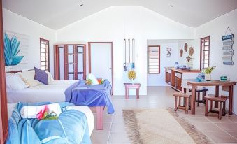 a spacious living room with two beds , a dining area , and a kitchen , all decorated in white and blue colors at Le Life Resort