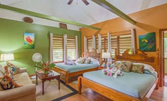 a room with two beds , one on the left side and another on the right side at Bocawina Rainforest Resort