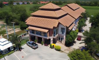 a large building with a tiled roof and multiple cars parked in front of it at Phusuay Park View Hotel