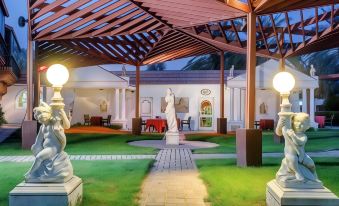 a courtyard with a statue of a woman , surrounded by a white building with red roofs at Marbella Resort