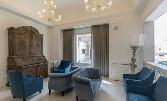 a room with a large window , blue and gray chairs , and chandeliers hanging from the ceiling at Grand Hotel Arenzano