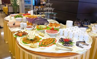 a dining table with a variety of food and drinks , including wine glasses , bowls , plates , and utensils at Gold Hotel Hue