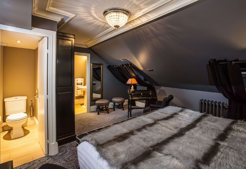 a bedroom with a large bed , a piano in the corner , and a doorway leading to another room at Hotel Vendome, BW Signature Collection