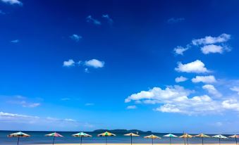 a beach with several umbrellas and chairs set up along the shore , creating a relaxing atmosphere at HaadSon Resort