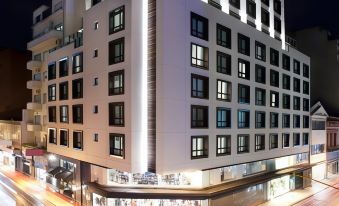 a city street at night , with a tall building on the left side of the scene at Hotel Pulitzer Buenos Aires