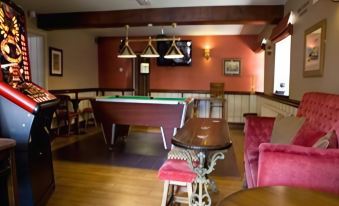 a bar with a pool table , chairs , and a tv , set in a cozy restaurant at Black Lion Hotel