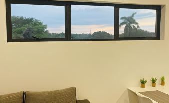 a room with a couch , table , and table lamp is shown with a view of the sky through three windows at Sweet Home Alibama
