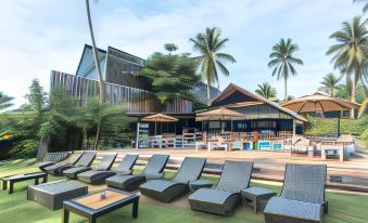 a resort with multiple buildings , a pool area , and lounge chairs on a grassy lawn at Siargao Island Villas