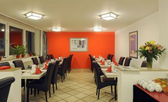 a dining room with a long table and chairs arranged for a group of people to sit and enjoy a meal together at Bellevue Hotel