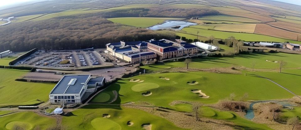 a large building with a green roof is surrounded by a golf course and other structures at Whittlebury Hall and Spa