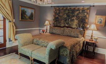 a luxurious bedroom with a large bed , a couch , and a chandelier hanging from the ceiling at Park Place Inn and Cottages