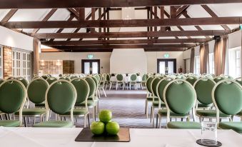 a conference room set up for a meeting , with chairs arranged in rows and a table in the center at The Haycock Manor Hotel