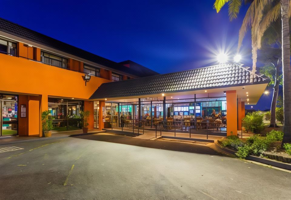 a restaurant with an orange facade and a white roof is lit up at night at Markets Hotel