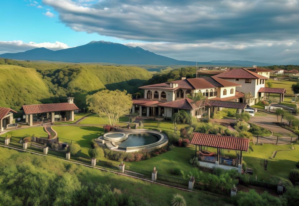 a large , luxurious villa surrounded by lush greenery and mountains , with a large pool and a gazebo in the center at Hacienda Los Molinos Boutique Hotel & Villas