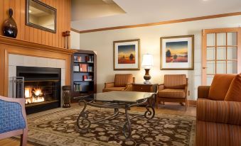 a living room with a fireplace , two chairs , and a coffee table in front of bookshelves at Country Inn & Suites by Radisson, Toledo, Oh