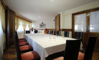 a large dining table with white tablecloth and chairs is set up in a room with a window at Berjaya Beau Vallon Bay Resort & Casino