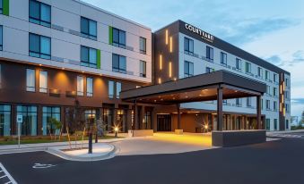 "a modern hotel building with the name "" courtyard by marriott "" lit up , surrounded by trees and a parking lot" at Courtyard Pasco Tri-Cities Airport