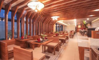 a large dining room with wooden tables and chairs , along with a staircase leading to the second floor at Swiss-Belinn Timika