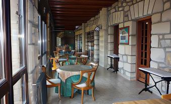 a stone building with wooden beams , tables with chairs on the floor , and artwork on the walls at Balneario de Corconte