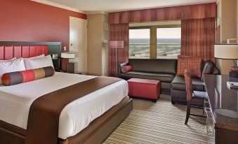 a hotel room with a bed , couch , and ottoman , along with a view of the ocean at Golden Nugget