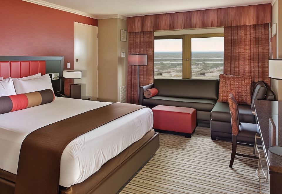 a hotel room with a bed , couch , and ottoman , along with a view of the ocean at Golden Nugget