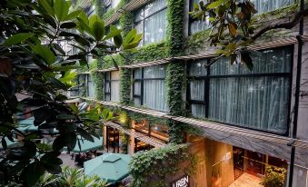 The outdoor seating area of the building features balconies and tables in front on the side at URBN Boutique Shanghai