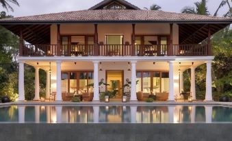 a large , two - story house with a pool in the front yard , surrounded by lush greenery at Eraeliya Villas & Gardens