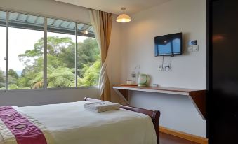 a bedroom with a bed , desk , and television is shown with a view of the outdoors at AYANA Holiday Resort