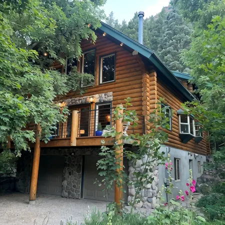 Cozy log cabin secluded in a mountain forest with hot tub, sauna, private patio.