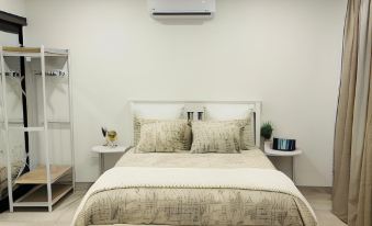 a modern bedroom with a white bed , beige curtains , and an air conditioner on the wall at Sweet Home Alibama