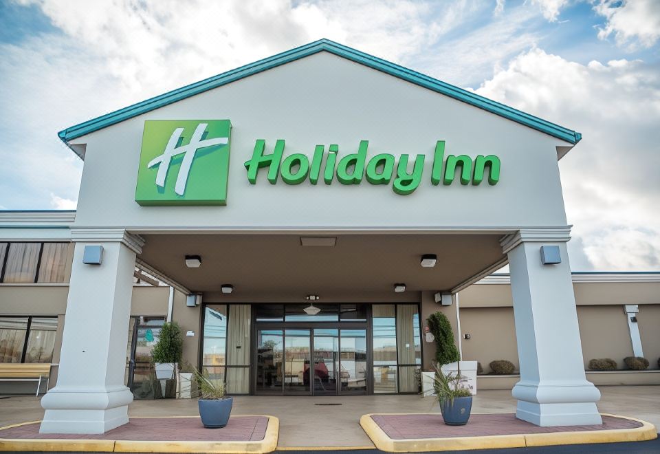 a holiday inn hotel entrance with a large sign above the door , indicating its name at Holiday Inn Hazlet