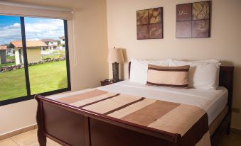 a bed with a wooden headboard and brown sheets is in a room with a window overlooking the outdoors at Hacienda Los Molinos Boutique Hotel & Villas