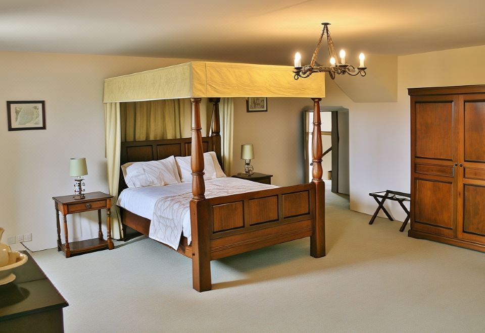 a large bedroom with a four - poster bed and a canopy over it , creating a cozy and inviting atmosphere at Leslie Castle