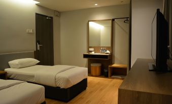 a hotel room with two beds , a desk , and a mirror , as well as a bathroom visible through the mirror at Go Hotel