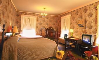 a cozy bedroom with a large bed , a desk , and a chair , decorated with flowers and curtains at White Inn