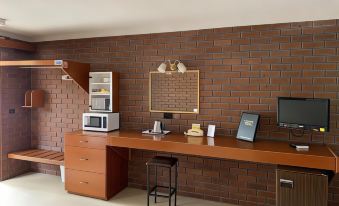 a brick wall with a wooden desk and a chair , along with a microwave and other items at Econo Lodge Lilydale
